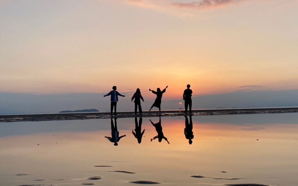 海でポーズをとる4人